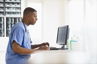 Male doctor in hospital using digital tablet.