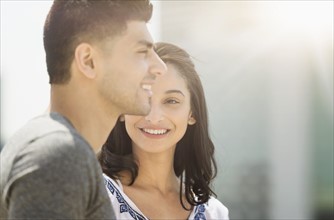 Young couple smiling in sunlight.