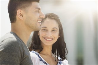 Young couple smiling in sunlight.