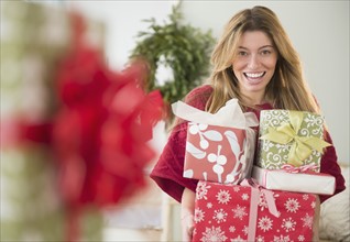 Portrait of woman holding christmas presents.
Photo : Jamie Grill