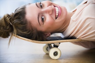 Portrait of young woman lying down on skateboard.
Photo : Jamie Grill