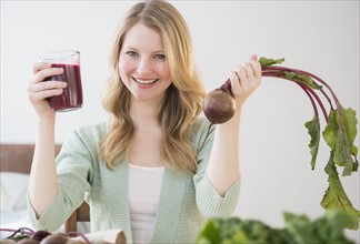 Woman holding beetroot and juice.
Photo : Jamie Grill