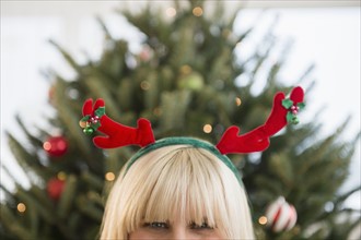 Blond woman wearing reindeer headband.
Photo : Jamie Grill