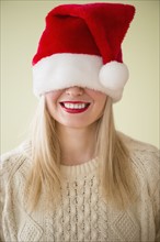 Studio Shot of woman wearing santa hat smiling.
Photo : Jamie Grill