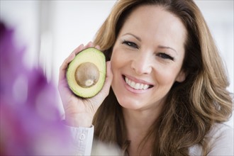Portrait of woman holding avocado.
Photo : Jamie Grill