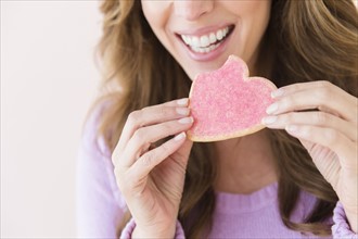 Woman holding heart shape cookie.
Photo : Jamie Grill