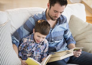 Father reading books with his son (8-9).
Photo : Jamie Grill