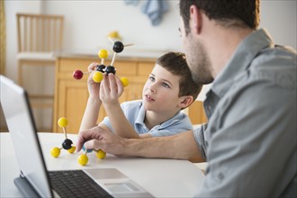 Father and son (8-9) looking at molecule model stack.
Photo : Jamie Grill