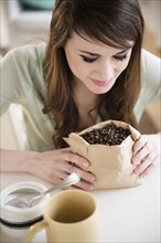 Young woman smelling coffee beans.
Photo : Jamie Grill