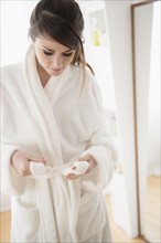 Young woman wearing white bathrobe.
Photo : Jamie Grill