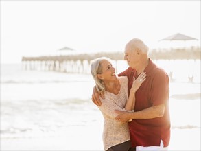 Senior couple embracing on beach.
Photo : Daniel Grill