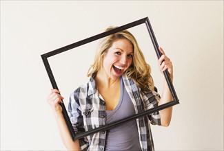 Portrait of woman holding picture frame.
Photo : Daniel Grill