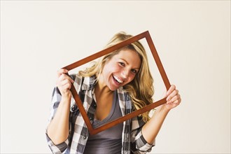 Portrait of woman holding picture frame.
Photo : Daniel Grill