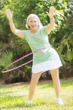 Portrait of senior woman spinning hula hoop.
Photo : Daniel Grill