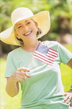 Portrait of woman holding american flag.
Photo : Daniel Grill
