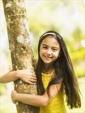 Portrait of girl ( 8-9) hugging tree trunk.
Photo : Daniel Grill