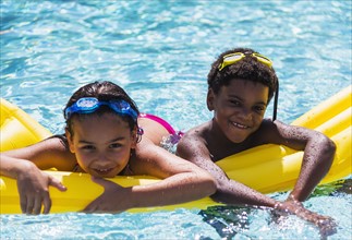 Portrait of kids( 6-7, 8-9) with pool raft.
Photo : Daniel Grill