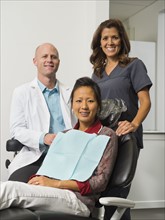 Portrait of dentist with patient and assistant.