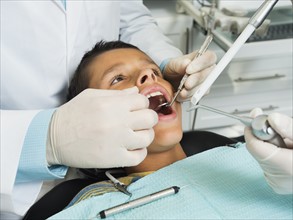 boy (10-11) being treated in dentist's office.