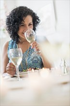 Woman tasting wine in restaurant.