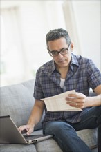 Man doing home finances with laptop.