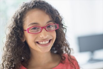 Portrait of schoolgirl (8-9) wearing pink eyeglasses.