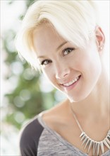 Portrait of blonde woman wearing necklace.