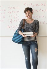 Portrait of young woman in front of whiteboard.