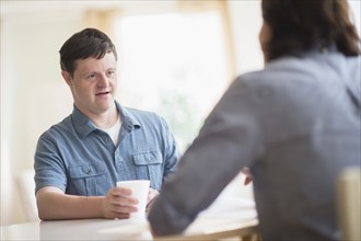 Man with down syndrome talking with care taker.