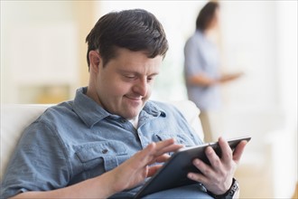 Man with down syndrome using tablet.