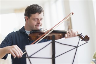 Man with down syndrome playing violin.