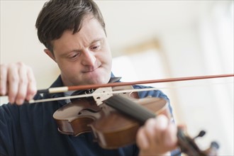 Man with down syndrome playing violin.