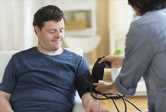 Man with down syndrome having blood pressure measured.