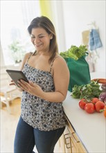 Woman with tablet pc in kitchen.