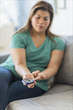 Woman sitting on sofa with mobile phone.