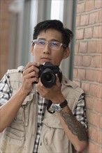 Portrait of man holding camera.