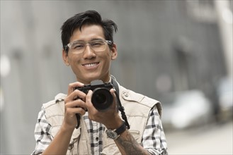 Portrait of man holding camera.