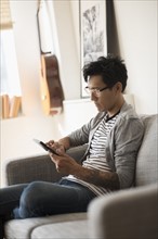 Man sitting on sofa and using tablet.