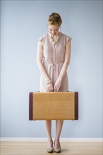 Young woman holding suitcase