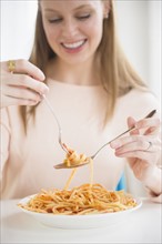 Young woman eating fettuccini