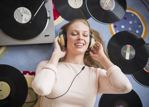 Young woman listening to music on vinyl record