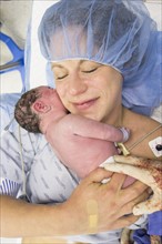 Mother holding newborn daughter