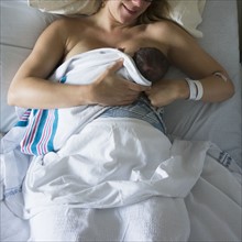 Mother breastfeeding newborn daughter