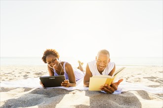 Man and woman reading on beach