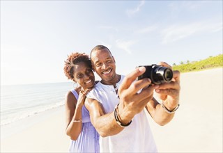 Man and woman photographing on beach