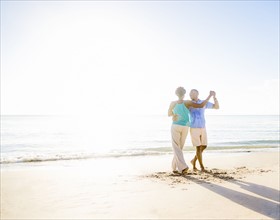 Mature couple dancing on beach