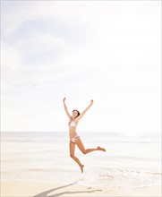 Woman jumping on beach