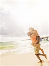 Young couple playing on beach