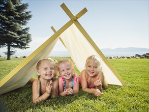 Three girls (2-3, 4-5) playing in tent