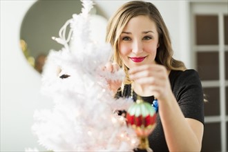 Young woman holding Christmas ornament
